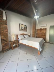 a bedroom with a bed and a table in it at Pousada Robijn in Cabo de Santo Agostinho