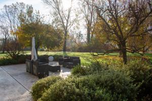 um pátio com cadeiras e um guarda-sol num parque em Ca' del Sile em Morgano