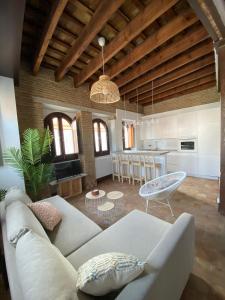 uma sala de estar com um sofá branco e uma cozinha em Hostfy Centro, Puerta Osario em Sevilha