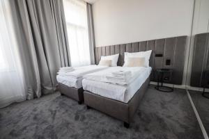 a bedroom with a bed with white sheets and a window at The Gold Bank in Prague