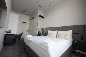 a bedroom with a large white bed and a desk at The Gold Bank in Prague