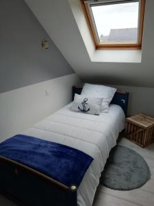 a bed in a room with a window at ANCRE BLEU in Hillion