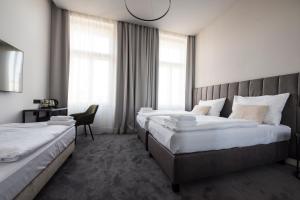 a hotel room with two beds and a chair at The Gold Bank in Prague