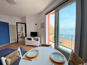 a dining room with a table and a large window at San Sisinio Apartment Argegno in Argegno