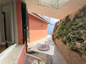 a table with a plate on it on a balcony at San Sisinio Apartment Argegno in Argegno