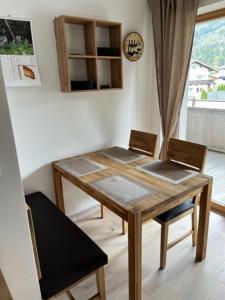 a dining room table with two chairs and a clock at Christinenhof Top 5 mit großem Balkon in Lofer