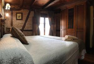 a bedroom with a large white bed with a window at Hospederia Casa de Cisneros in Toledo
