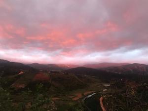 a sunset over a mountain valley with a river at Midori Coffee Farm in Da Lat