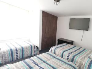 Habitación de hotel con 2 camas y TV de pantalla plana. en Andina Lodge, en Arequipa