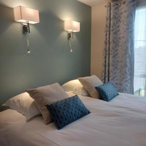 1 dormitorio con 2 camas y almohadas azules en Logis hôtel le relais de l'abbaye, en Saint-Évroult-Notre-Dame-du-Bois