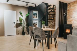 a dining room with a table and chairs and a brick wall at Rezydencja Bieszczady - Solina in Solina