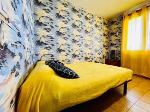 1 dormitorio con cama con sábanas amarillas y pared con papel pintado en P Alberes BJ2, en Empuriabrava