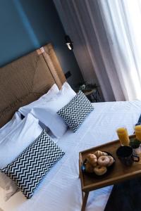 a bed with pillows and a tray of food on it at Nuovo Luxury Suite in Malia