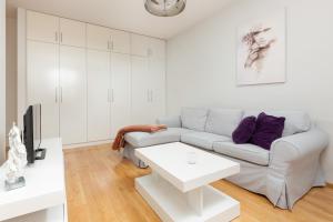 uma sala de estar branca com um sofá e uma mesa em Apartament Na Woli Sowińskiego by Renters em Varsóvia