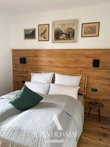 Schlafzimmer mit einem großen Bett mit einem Kopfteil aus Holz in der Unterkunft Alpenhoamat Apartments in Garmisch-Partenkirchen