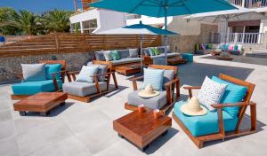 a patio with chairs and tables and an umbrella at Ayour - Ocean by Coralia - 6 Px in Agadir