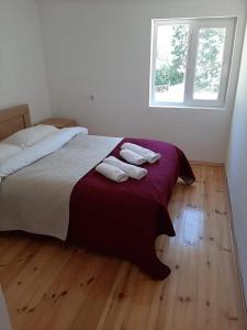 una camera da letto con un letto e due asciugamani di Gama Guesthouse a Roshka