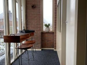 a room with a desk and a brick wall at Logeren bij Grea in Zwartsluis