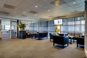 a waiting room with chairs and a projection screen at Sportshotel Vejen in Vejen