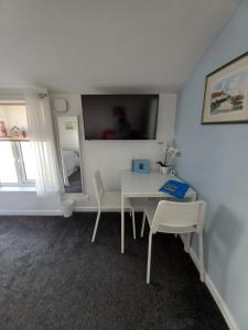 a dining room with a table and two chairs at The Garden Suite Holt in Holt