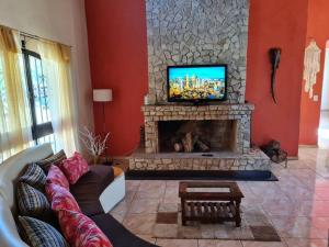a living room with a fireplace with a tv on top at HERMOSA CASA con 4000mts de PARQUE en las SIERRAS DE CORDOBA in José de la Quintana
