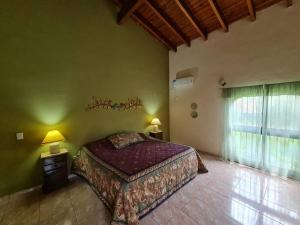 a bedroom with a large bed and a window at HERMOSA CASA con 4000mts de PARQUE en las SIERRAS DE CORDOBA in José de la Quintana +27 photos