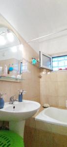 Holiday & Business Furnished Apartments في ميتيكاس: حمام مع حوض وحوض استحمام
