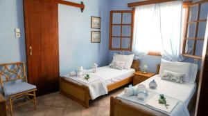 a bedroom with two beds and a chair at VILLA DREAM in Skiathos Town