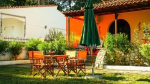 a patio with a table and a green umbrella at VILLA DREAM in Skiathos Town