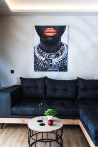 a living room with a black couch and a painting at Nuovo Luxury Suite in Malia