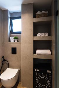 a bathroom with a toilet and towels on a shelf at Nuevo Malia Suite in Malia +37 photos