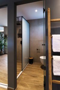 a bathroom with a glass shower door and a toilet at Nuovo Luxury Suite in Malia