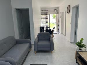 a living room with a couch and a chair and a table at RDC - Appartement F3 Villiers le Bel 95 Proche de Paris Roissy in Villiers-le-Bel