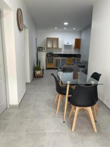 a living room with a table and chairs and a kitchen at RDC - Appartement F3 Villiers le Bel 95 Proche de Paris Roissy in Villiers-le-Bel +8 photos
