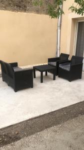 tres sillas negras y una mesa en una acera en RDC - Appartement F3 Villiers le Bel 95 Proche de Paris Roissy en Villiers-le-Bel