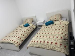 two beds sitting next to each other in a bedroom at RDC - Appartement F3 Villiers le Bel 95 Proche de Paris Roissy in Villiers-le-Bel