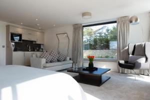 um quarto com uma cama, uma cozinha e uma sala de estar em Dafarn Newydd Studio em Llangefni