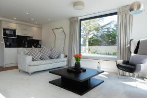 a living room with a couch and a table at Dafarn Newydd Studio in Llangefni