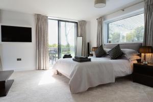 a bedroom with a large bed and a large window at Dafarn Newydd Studio in Llangefni