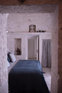 ロコロトンドにあるIl Trullo di Benの石壁のベッドルーム1室
