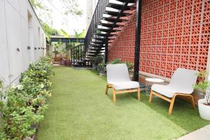 a courtyard with two chairs and grass at Waltair Abode in Visakhapatnam