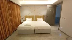 a bedroom with a large bed with white sheets at Waltair Abode in Visakhapatnam