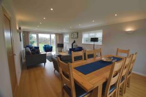 a dining room and living room with a table and chairs at Spacious 5 bed in the countryside, close to Frinton-On-Sea in Kirby Cross