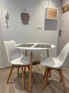 サヴィニー・レ・ボーヌにあるChez la p'tite Marieのテーブルと白い椅子2脚