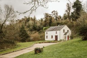 a white house on the side of a road at Innish Beg Cottages in Blaney