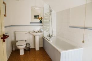 a white bathroom with a toilet and a sink at Innish Beg Cottages in Derrygonnelly