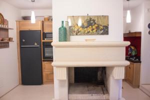 a fireplace in a kitchen with a painting on the wall at Amata Casa in Muro Leccese