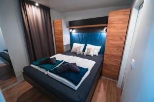 ein Schlafzimmer mit einem großen Bett mit blauer Bettwäsche und Kissen in der Unterkunft Mobile Home Symphony in Biograd na Moru