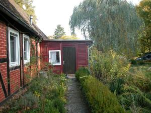 Ferienwohnung Zeitenhof في Suderburg: منزل احمر على جانبه باب