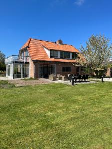 uma casa com um grande quintal em frente em Het Landhuis em Oostkapelle